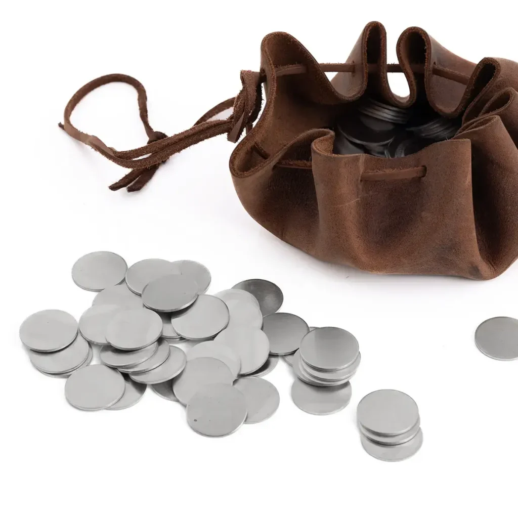 Aluminiowe krążki mennicze 24 mm wysypane obok skórzanej sakiewki